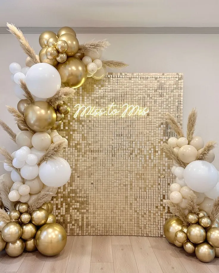 Bride to be shimmer backdrop balloon decoration with pure white and silver balloons, bride to be banner and artificial golden leaves by Event Experts UAE in Dubai Abu Dhabi Sharjah Ajman Ras Al Khaimah Fujairah Umm Al Quwain