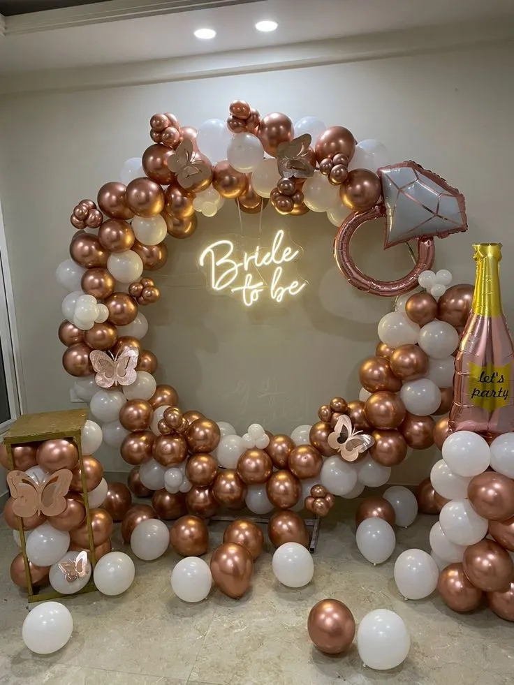Bride to be round arch balloon decoration with white and rose gold balloons, rose gold butterfly balloons, champagne bottle foil, ring foil, bride to be banner and floor balloons by Event Experts UAE in Dubai Abu Dhabi Sharjah Ajman Ras Al Khaimah Fujairah Umm Al Quwain
