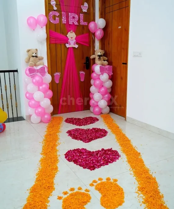 Welcome Baby balloon decoration with pink and white balloons, “Girl” letter banner in red, yellow rose petals, baby stickers, pink cloth, and 2 small teddy bears in Dubai, UAE by Event Experts.