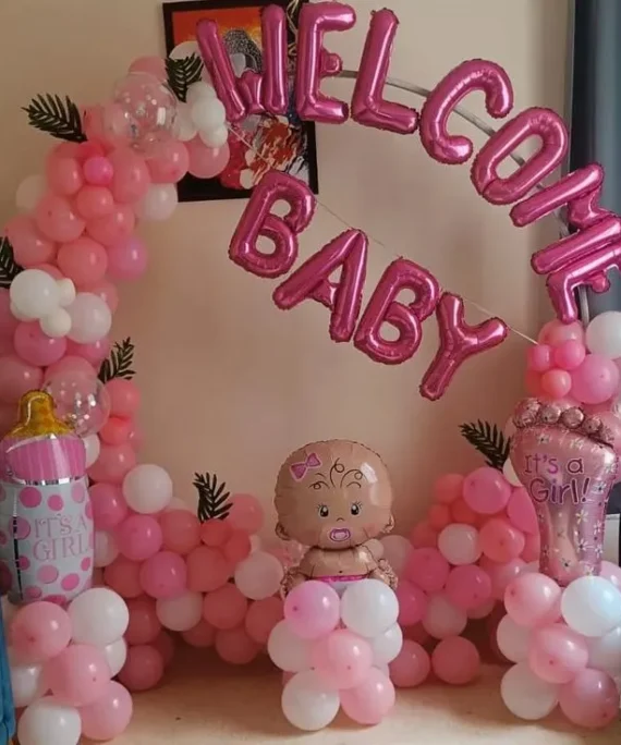 Welcome Baby round arch balloon decoration with white, pink, and transparent balloons, Welcome Baby pink foil, baby bottle foil, baby foil, and artificial leaves in Dubai, UAE by Event Experts.