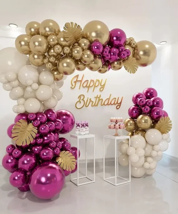 Maroon, golden and white half arch birthday balloon decoration with cake table and Happy Birthday wall sign in Dubai, UAE by Event Experts.