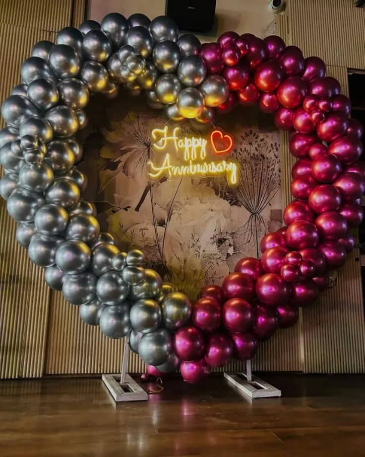 Anniversary balloon decoration with rose gold and silver balloons and anniversary neon light in Dubai, UAE by Event Experts.