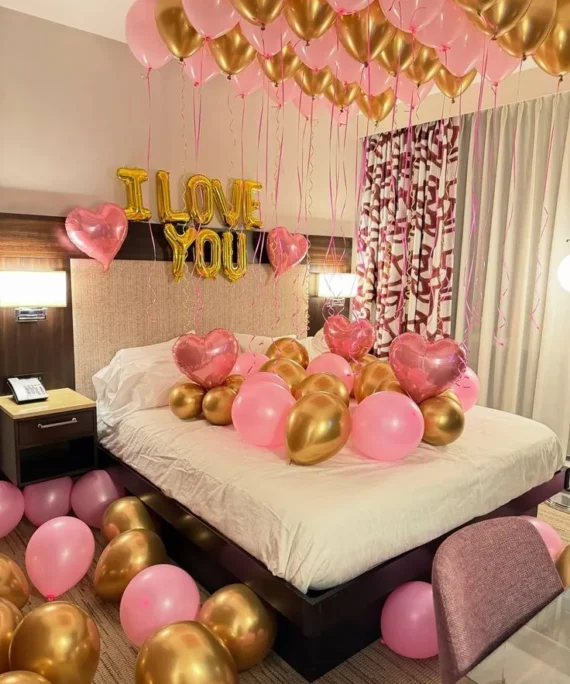 Valentine’s Day balloon decoration with pink and golden balloons, 5 foil heart balloons, floor and wall balloons, and “I Love You” foil balloon in Dubai, UAE by Event Experts.