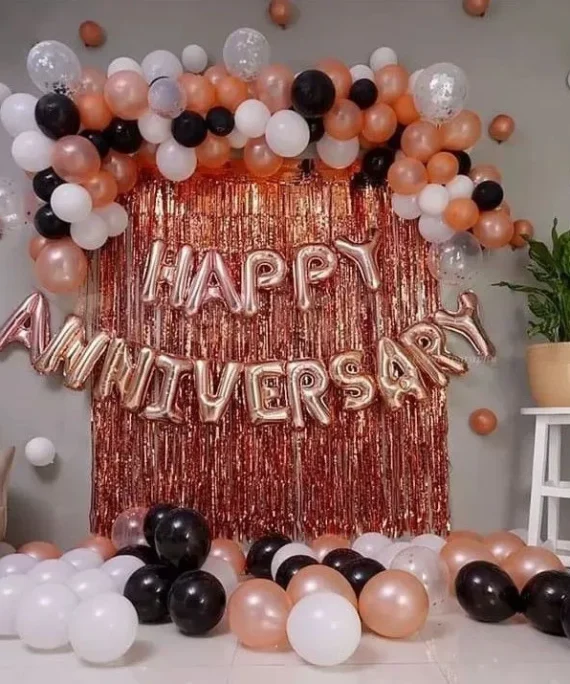 Anniversary room decoration with transparent, rose gold, black and white balloons featuring top half arch, rose gold backdrop banner and floor balloons by Event Experts UAE