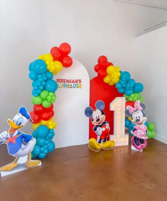Mickey Mouse birthday theme balloon decoration setup with red, yellow, ocean blue, and light green balloons featuring three Mickey Mouse character cutouts.