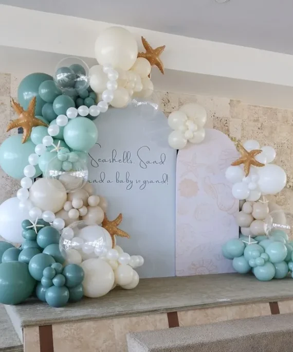 Mermaid theme double round arch backdrop balloon decoration setup with white, ocean blue, cream, sand white, and beige balloons, white star foam decorations, and five starfish foil balloons.
