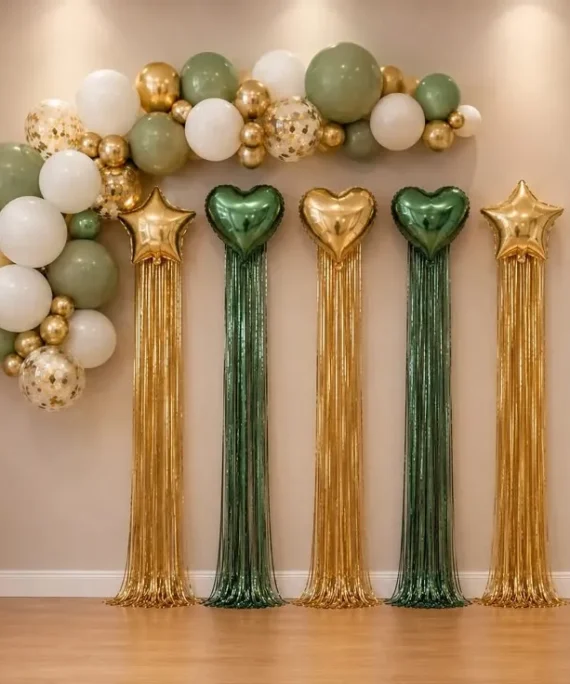 New Year simple wall balloon decoration setup with light green, white, gold, and transparent confetti balloons, gold star foil balloons, dark green heart foil balloons, silver Happy New Year foil balloons, shimmer wall, and white round cake table.