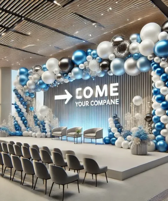 Corporate event big balloon arch decoration setup with light blue, white, dark blue, silver, and black balloons, artificial white flowers, large balloons, floor balloon bunches, wall balloons, and white round cake tables.