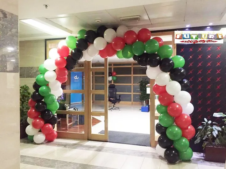 UAE National Day balloon arch decoration setup with black, white, red, and green balloons and matching balloon bunches on the wall.