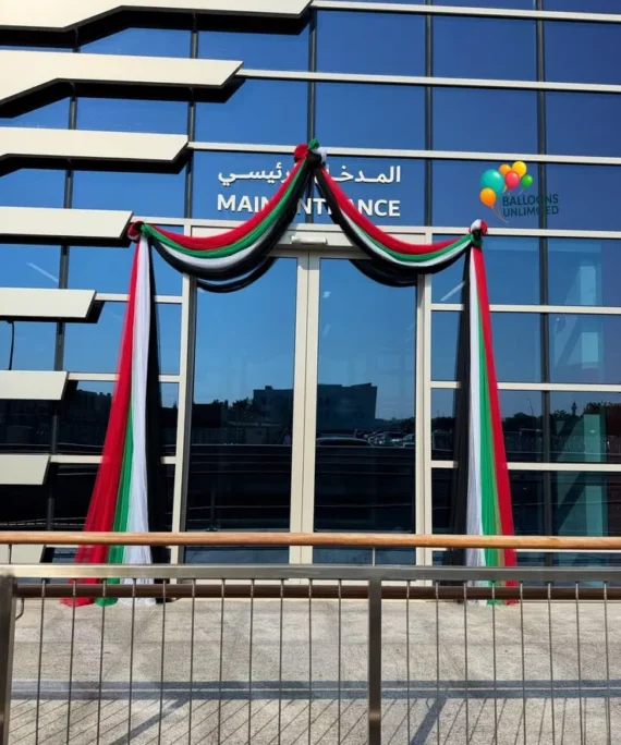 UAE National Day office reception balloon net decoration setup with red, black, green, and white balloon net, UAE foil balloons, UAE flags, and hanging balloon net décor.